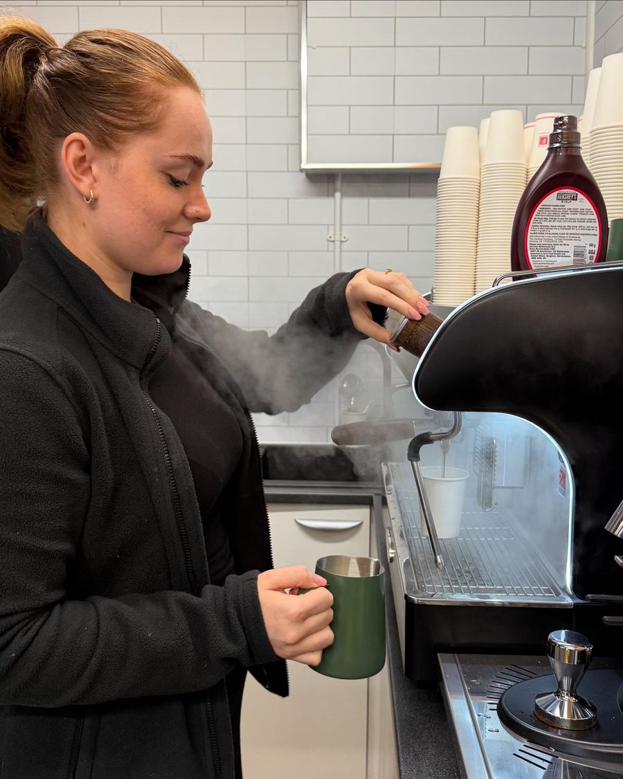A Nomad barista steaming milk at the espresso machine in the Redditch shop
