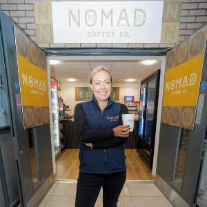 Cat outside the Nomad café at Worcestershire Parkway holding a coffee